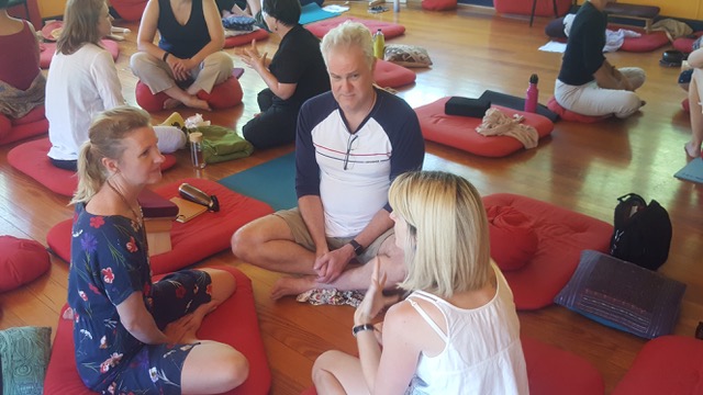 MTI close shot of triads Three people at meditation retreat sitting cross legged in discussion